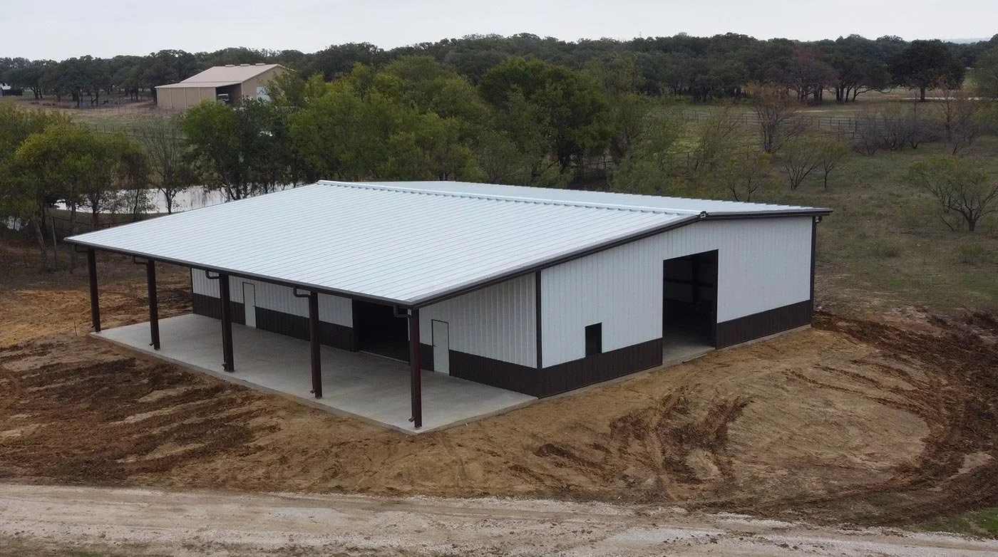 Large TOL metal building with white panels and brown trim, backed by warranty coverage